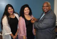 President Jimmie McCoy presents ATU Local 1700 pins to new union members Jocelyn Vaca, left, and Janeth Hernandez.